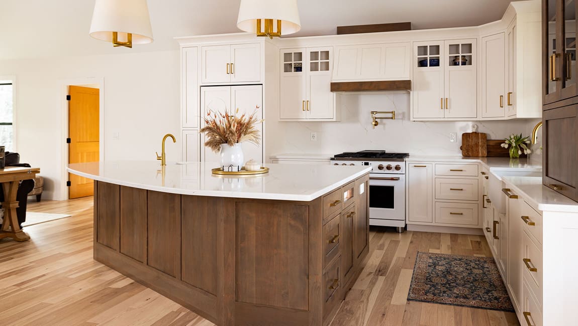 A Cabintie kitchen with a walnut island and white shaker cabinetry